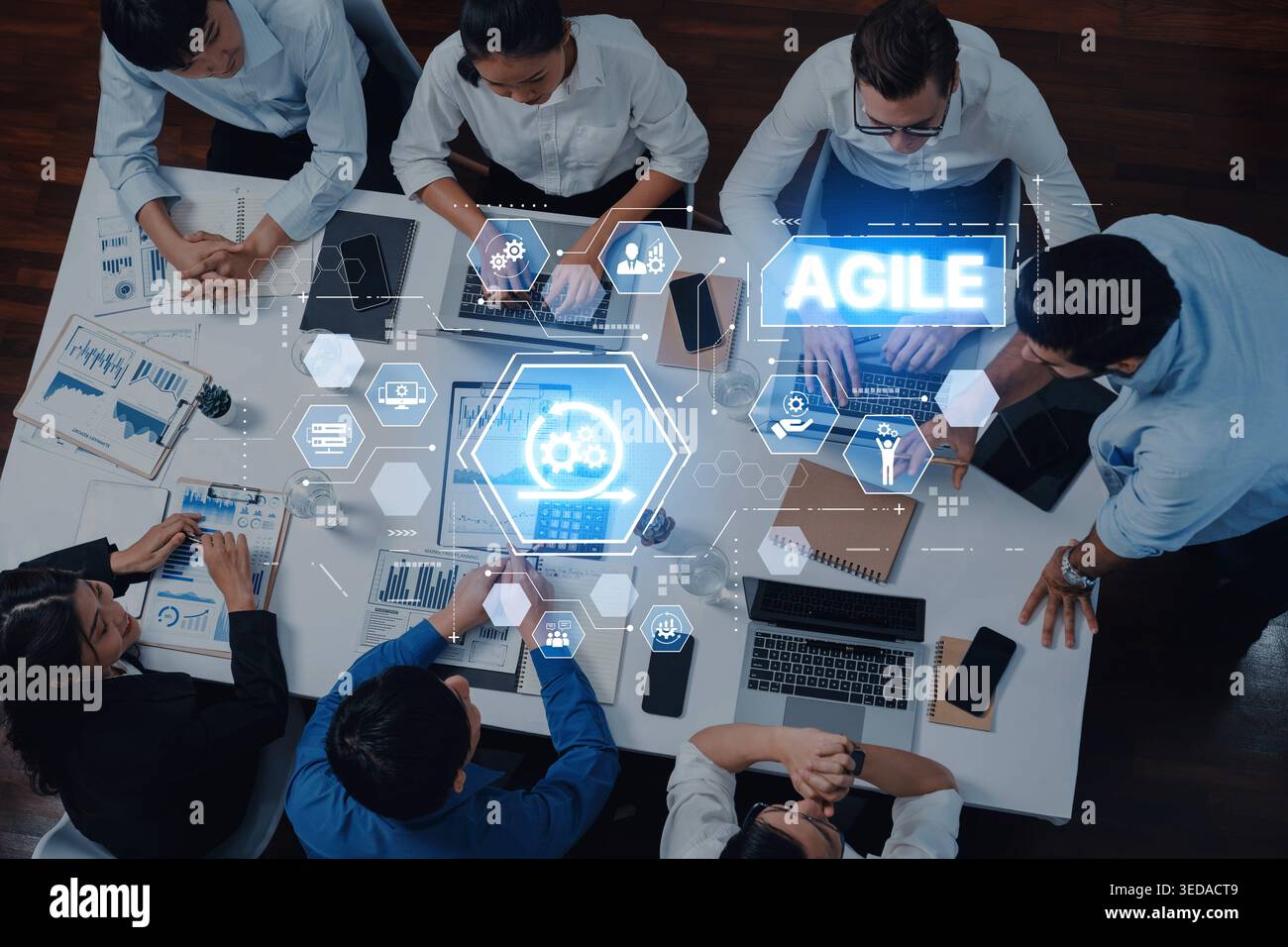 A diverse group of professionals engages in collaborative work using digital tools in an agile workspace, promoting effective communication and Stock Photo