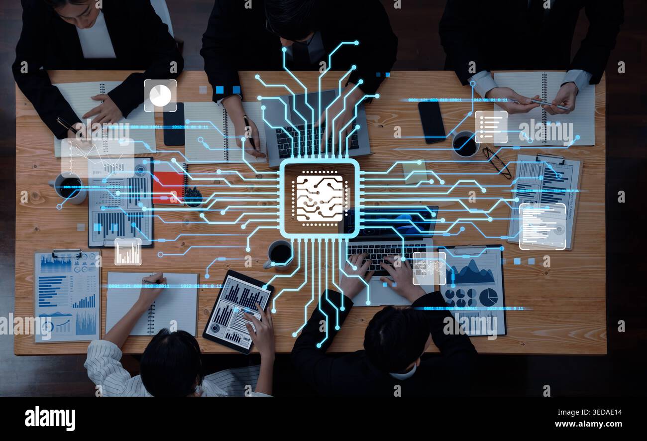 Professionals engage in a collaborative effort on an artificial intelligence project, utilizing technology, charts, and documents in a modern Stock Photo