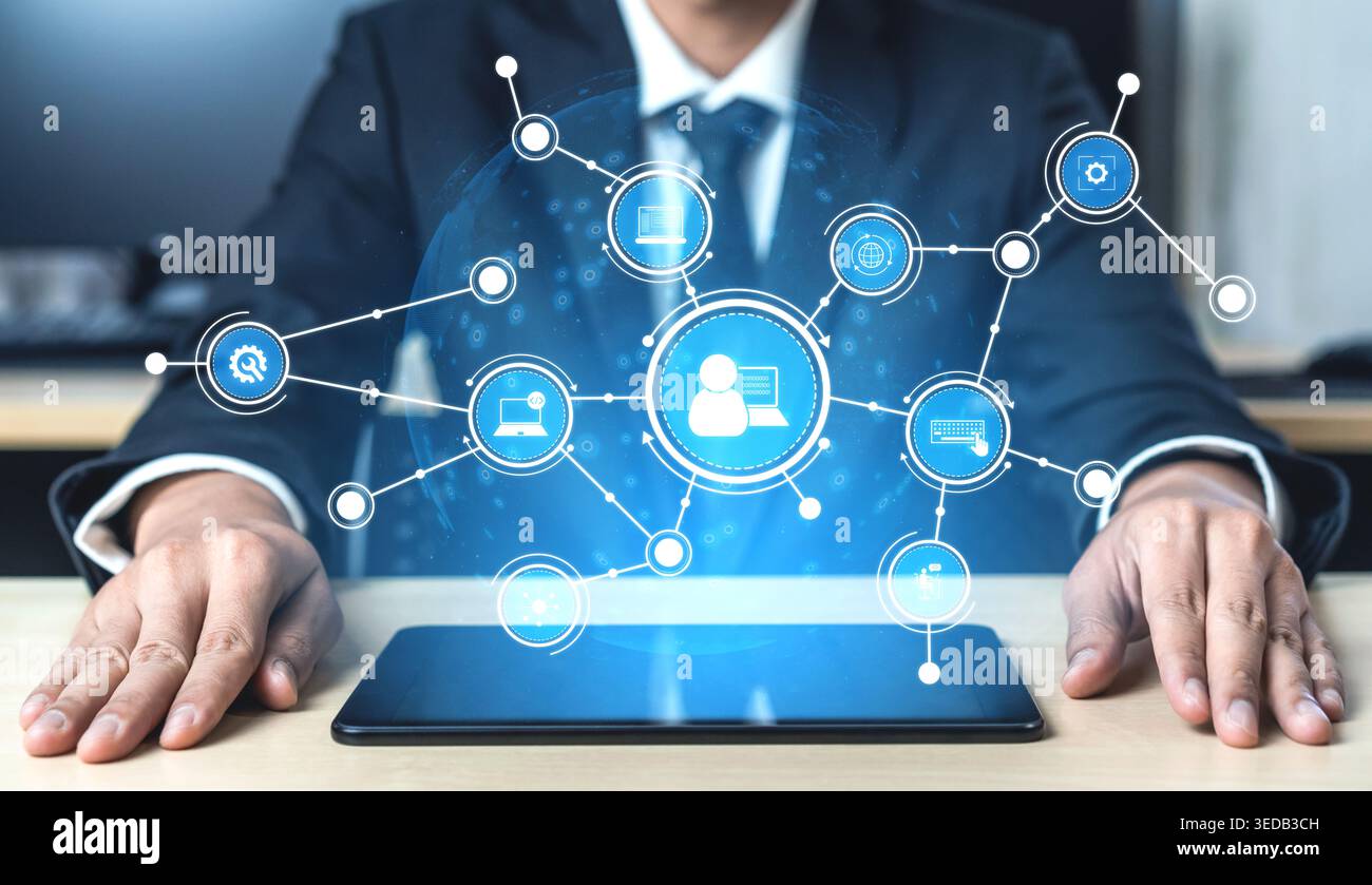 A business professional interacts with a tablet displaying a digital network, symbolizing technological advancement and data connectivity in an office Stock Photo