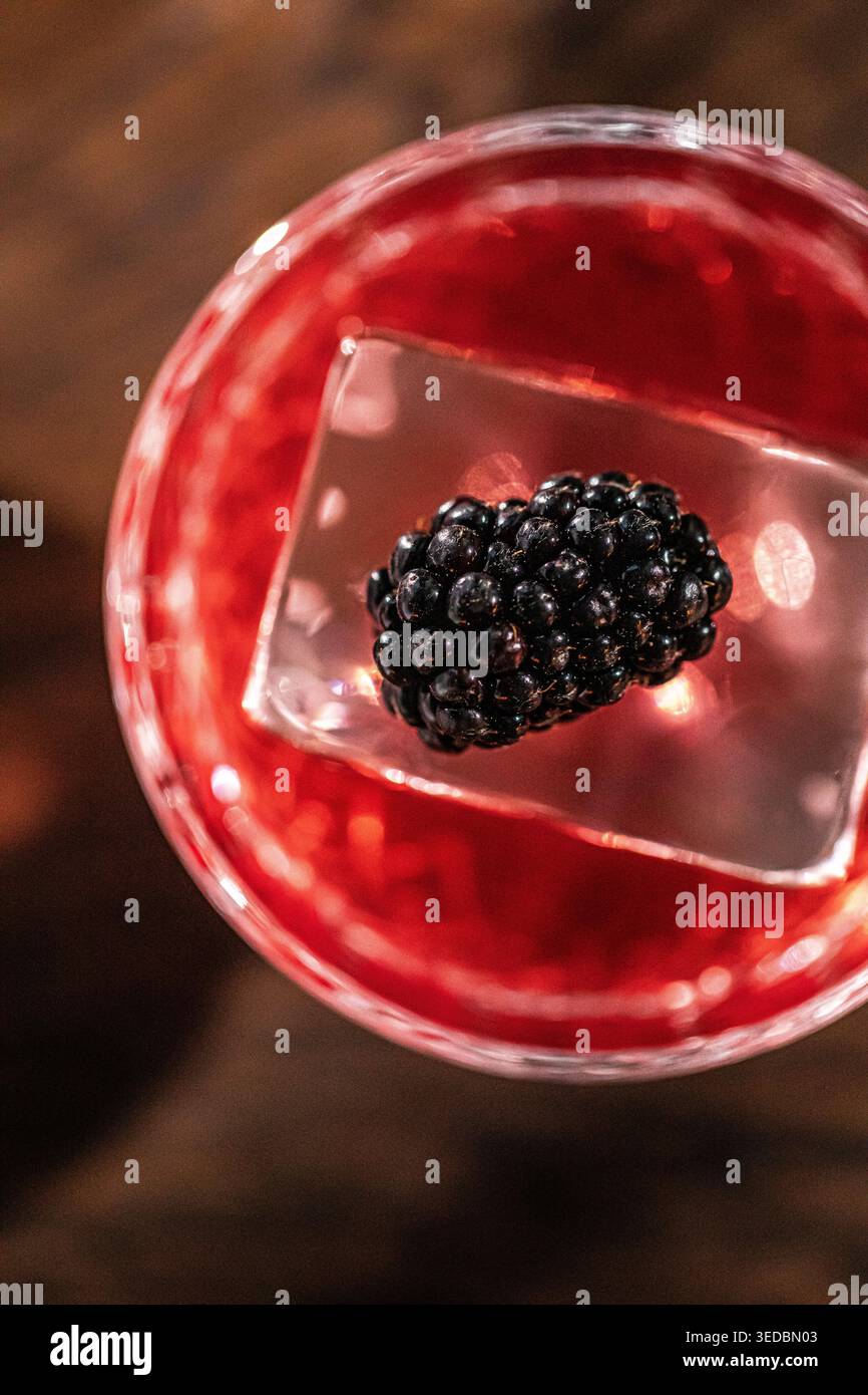 Red cocktail with blackberry on ice cube Stock Photo