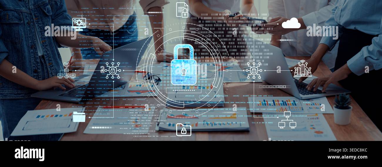 A dynamic team in a modern office setting collaborates on projects with laptops and documents, emphasizing cybersecurity and data protection in their Stock Photo