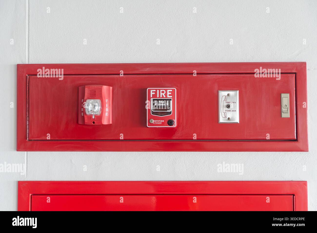 A detailed view of a red fire alarm system panel featuring alarms ...