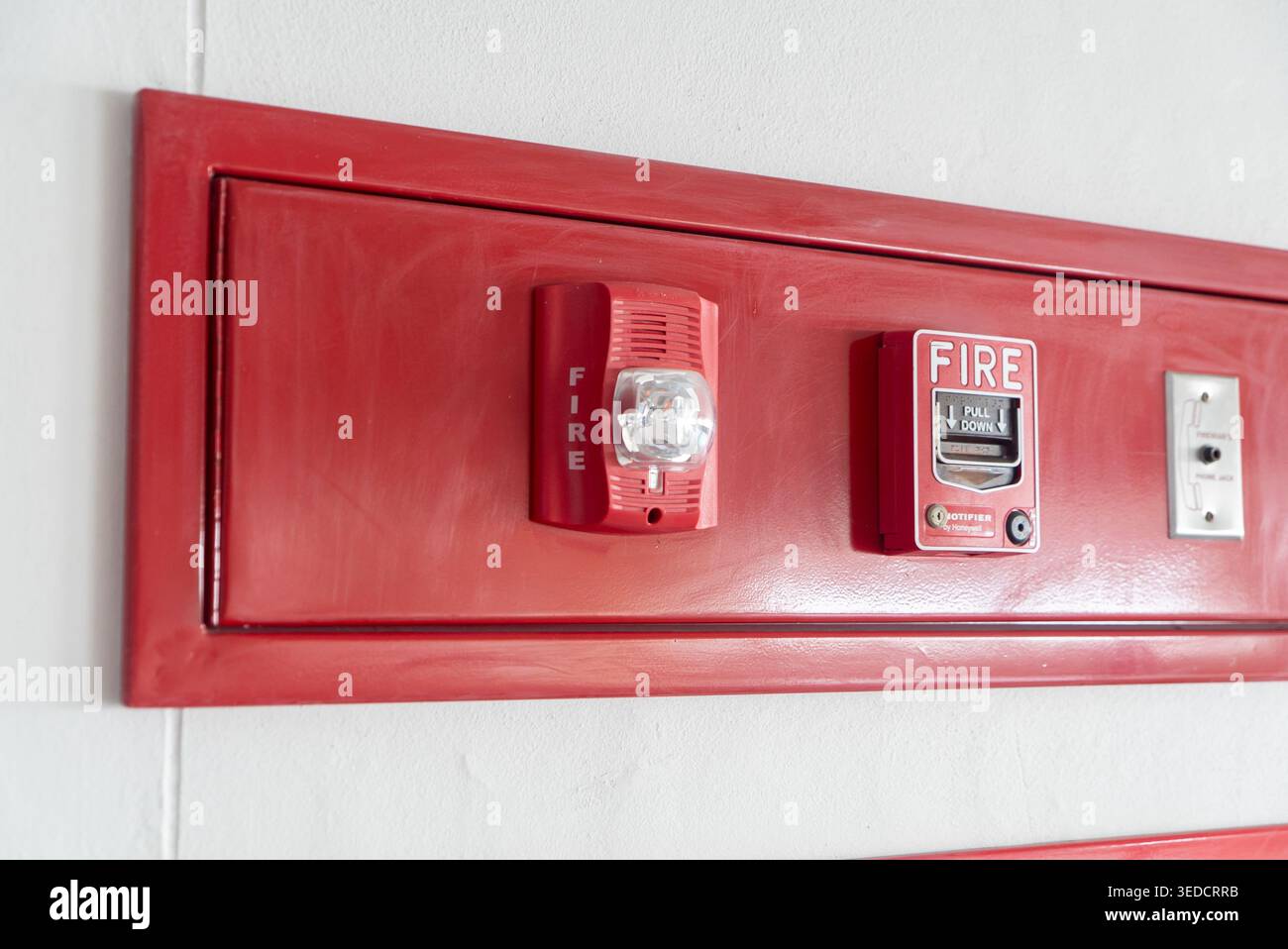Emergency Rspi This image shows a fire alarm system mounted on a red wall. It features ...