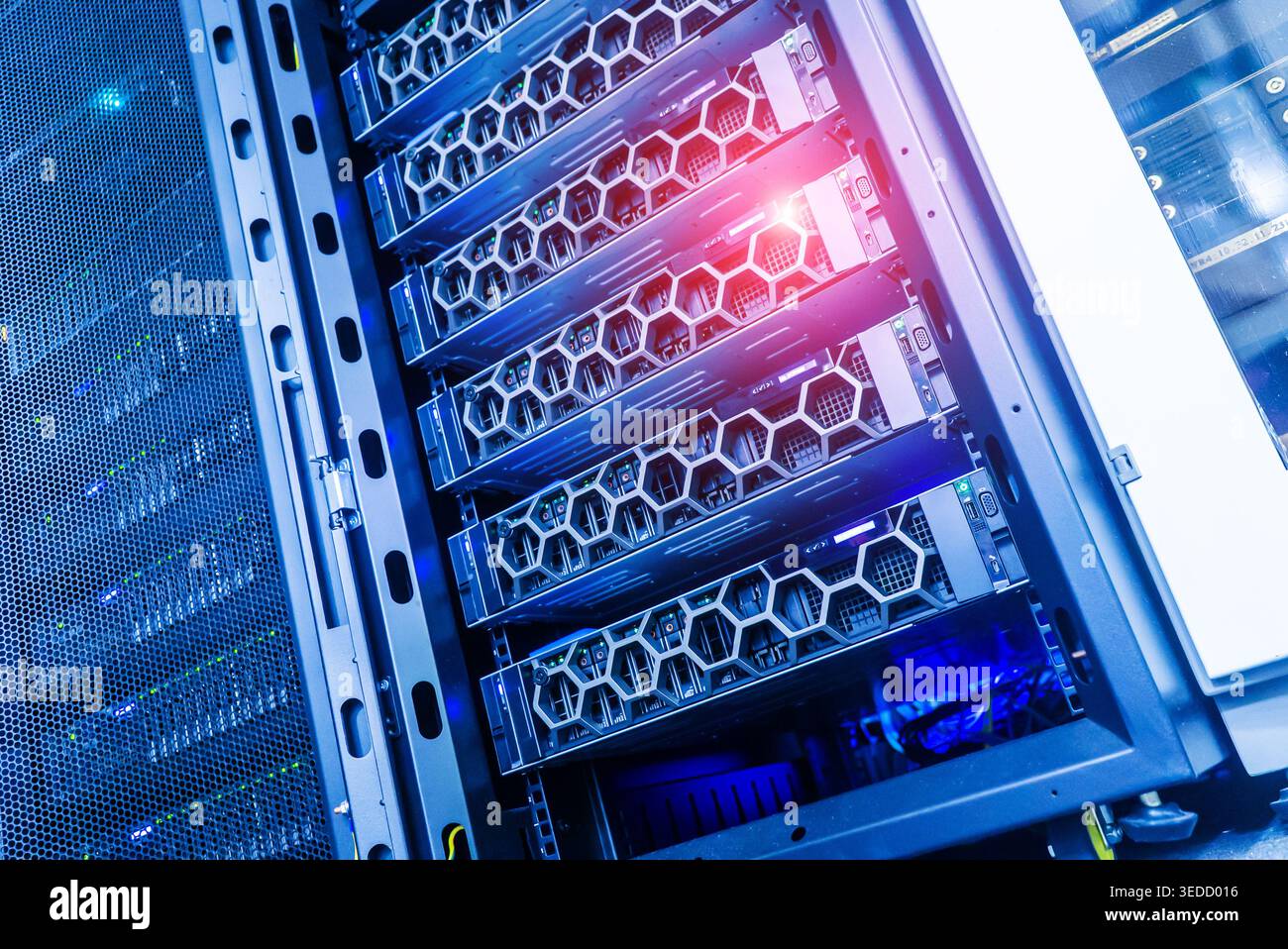 A view of a high-tech data center showcasing multiple computer servers in a secure rack. Bright lights highlight the advanced technology, emphasizing Stock Photo
