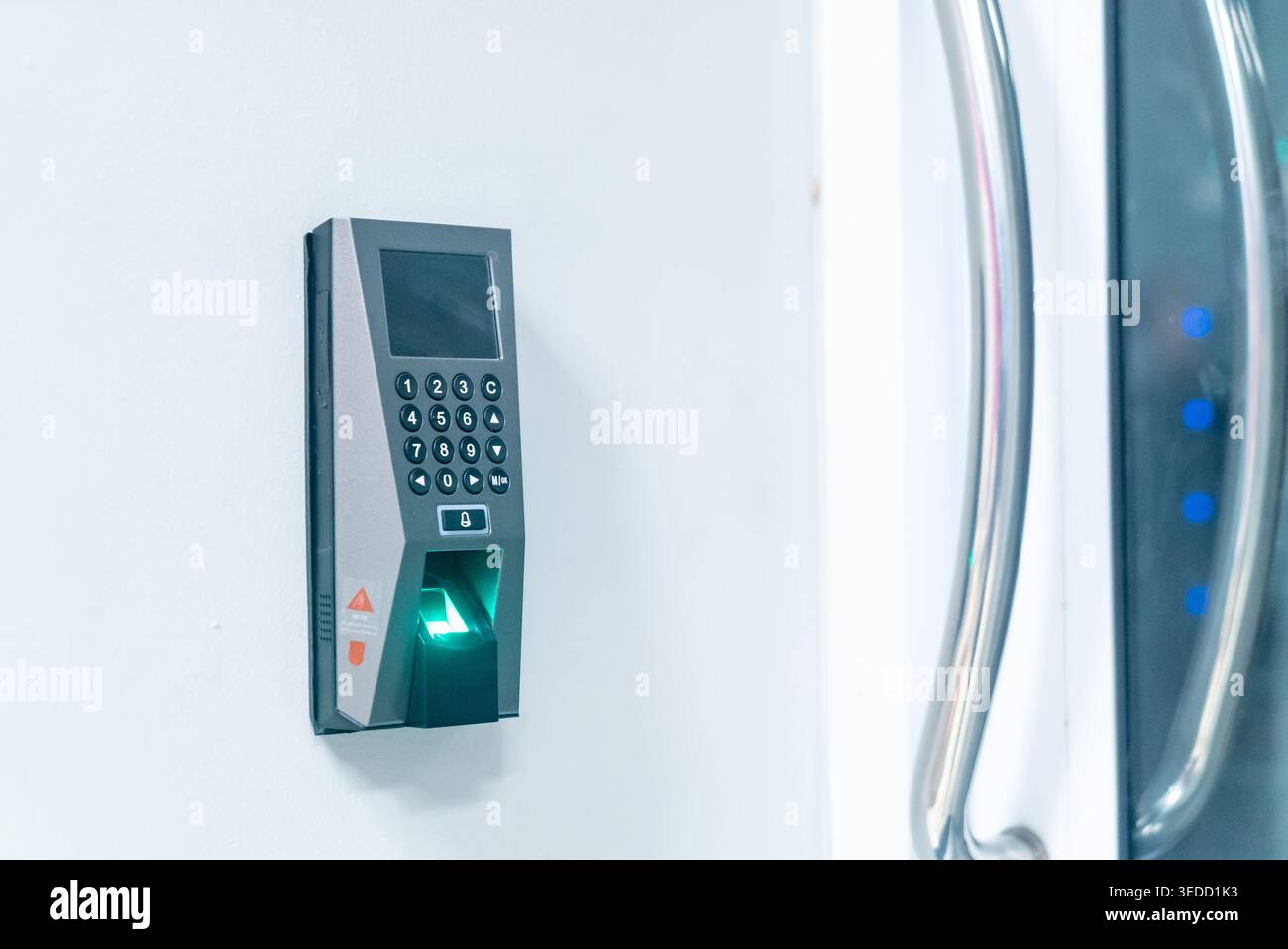 A modern biometric access control device mounted on a wall, featuring a sleek design and user-friendly interface for secure entry and identification. Stock Photo