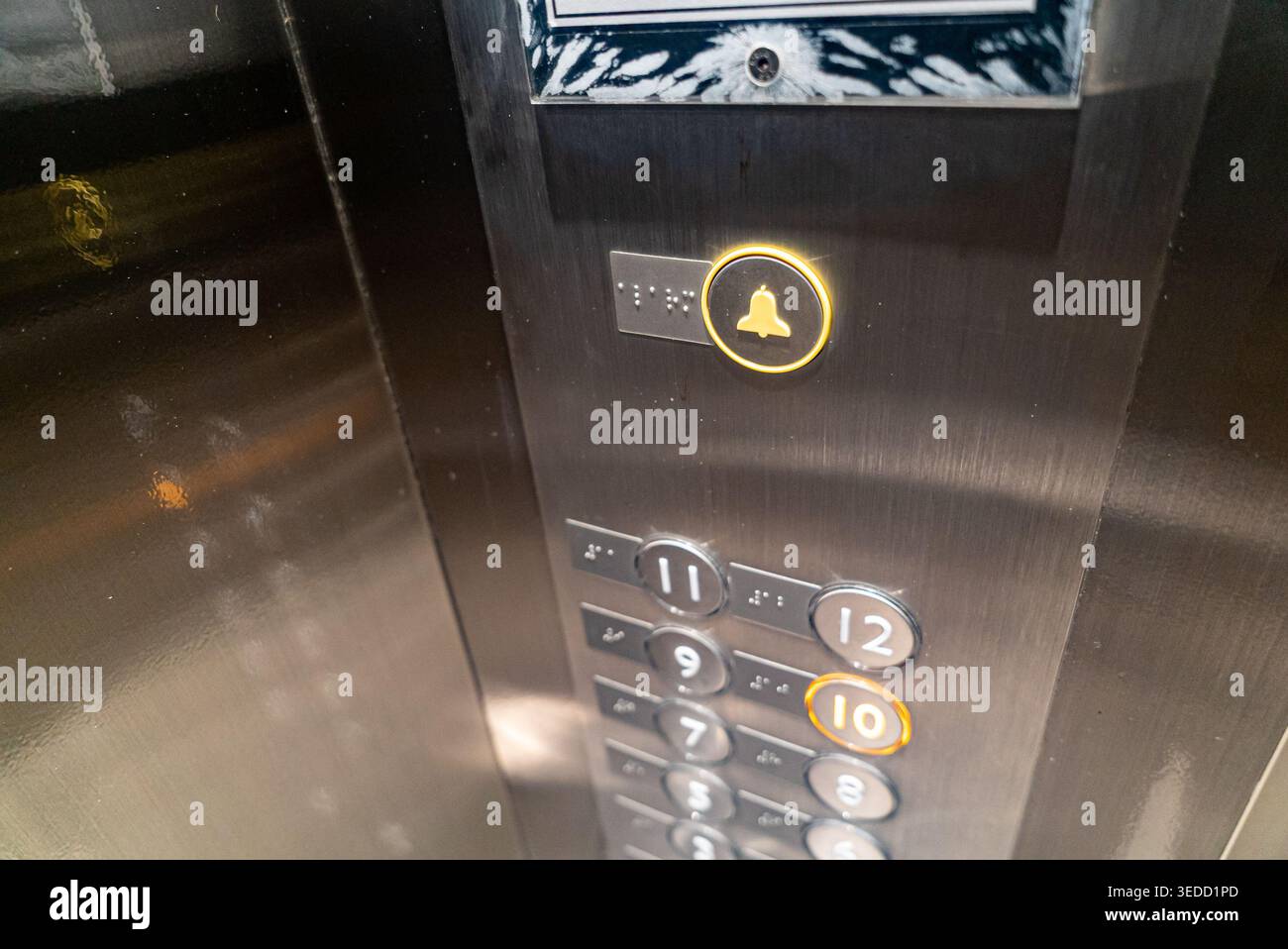 Close-up of an elevator control panel showcasing illuminated buttons for various floors, highlighting modern design and functionality in urban archite Stock Photo
