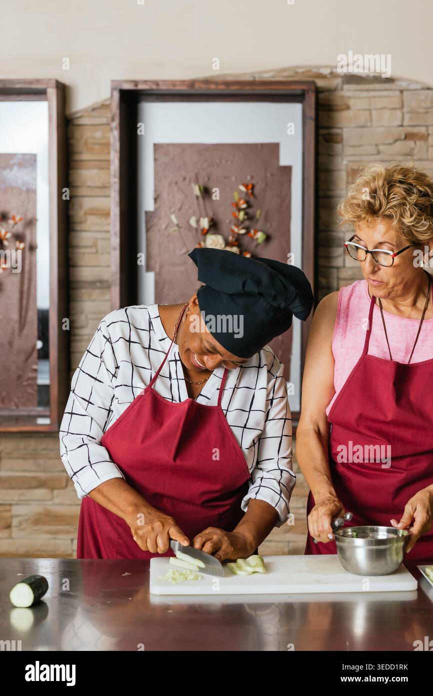 Chefs cutting vegetables during cooking course in restaurant kitchen Stock Photo