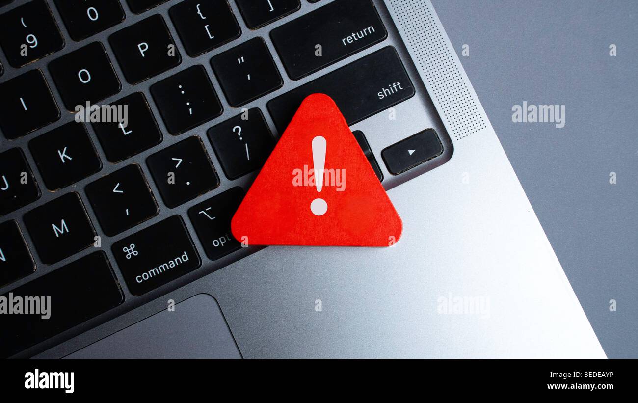 Red Warning Triangle with Exclamation Mark on Laptop Keyboard Highlighting Cyber Security Risk or System Error Stock Photo