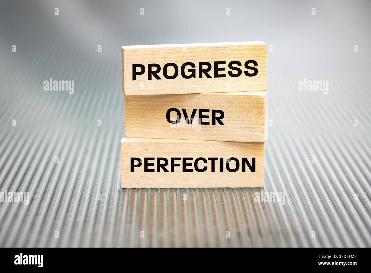 Progress over perfection. Sentence written on wooden tablets. Business concept. Motivating, supporting development. Close up. copy space Stock Photo
