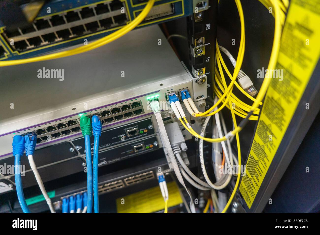 Close-up view of a network switch displaying various connections and cables, showcasing the intricate setup of a modern data communication infrastruct Stock Photo