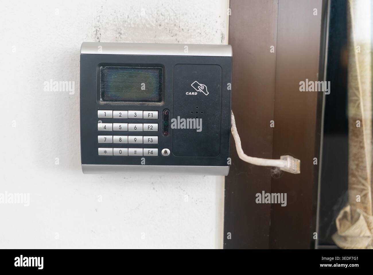 A modern intercom system designed for secure access features a keypad, display screen, and connection for audio communication, suitable for homes and Stock Photo