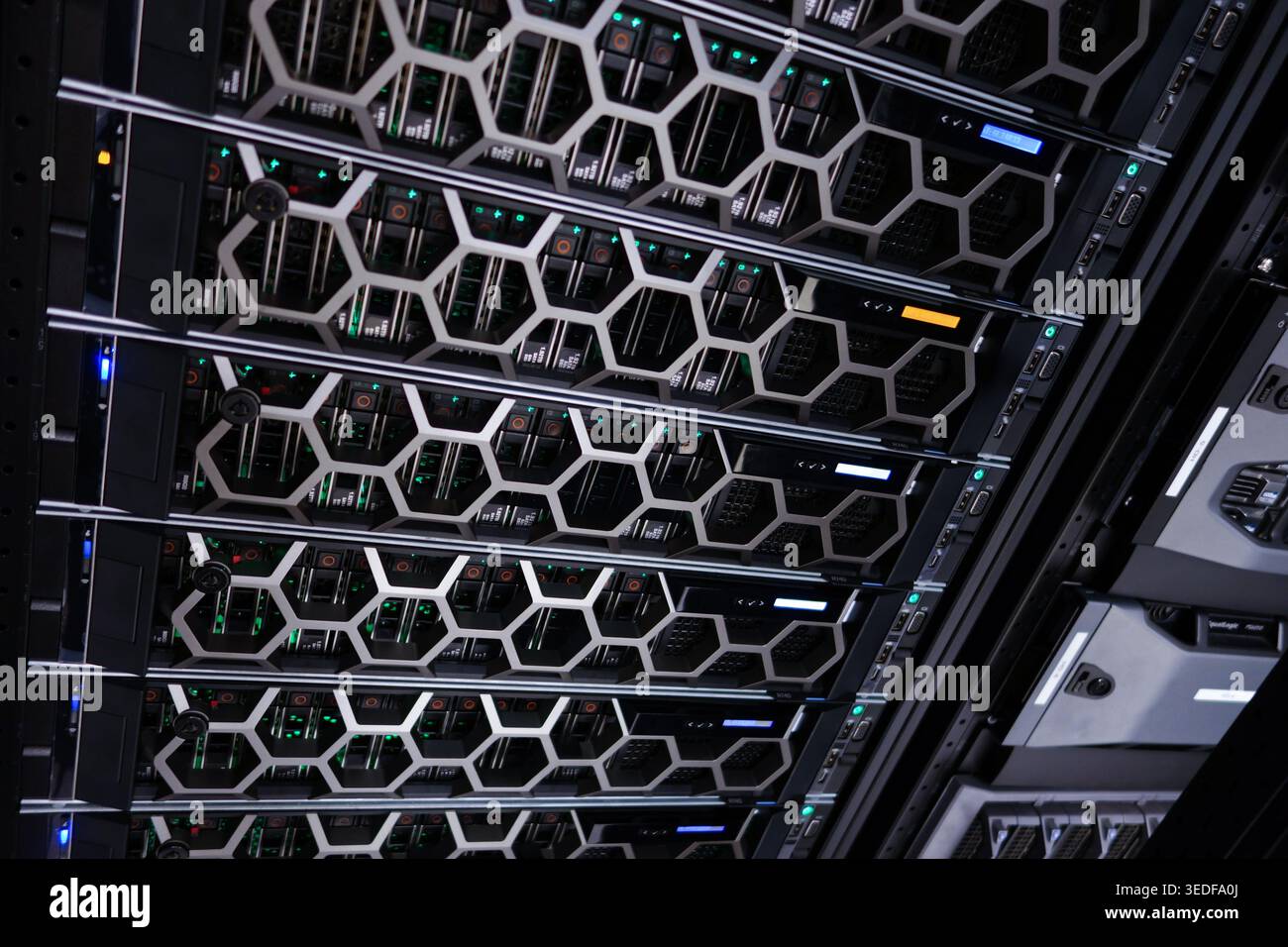 A modern data center showcasing server racks illuminated by various colored lights. The image exemplifies high-performance computing technology and ef Stock Photo