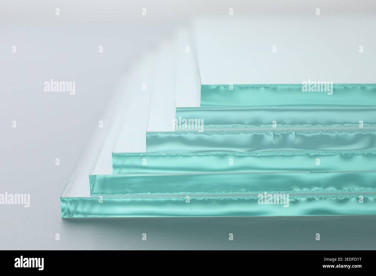 Stack of glass sheets on light background, closeup Stock Photo