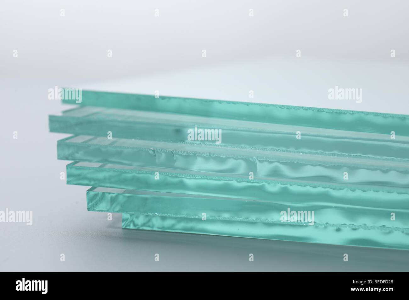 Stack of glass sheets on light background, closeup Stock Photo