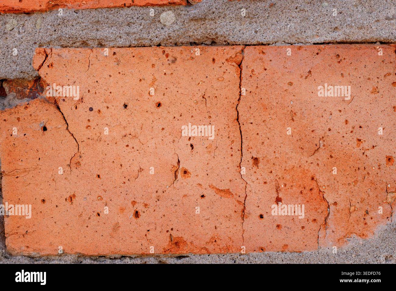 Cracked red brick texture macro, old wall building material background Stock Photo