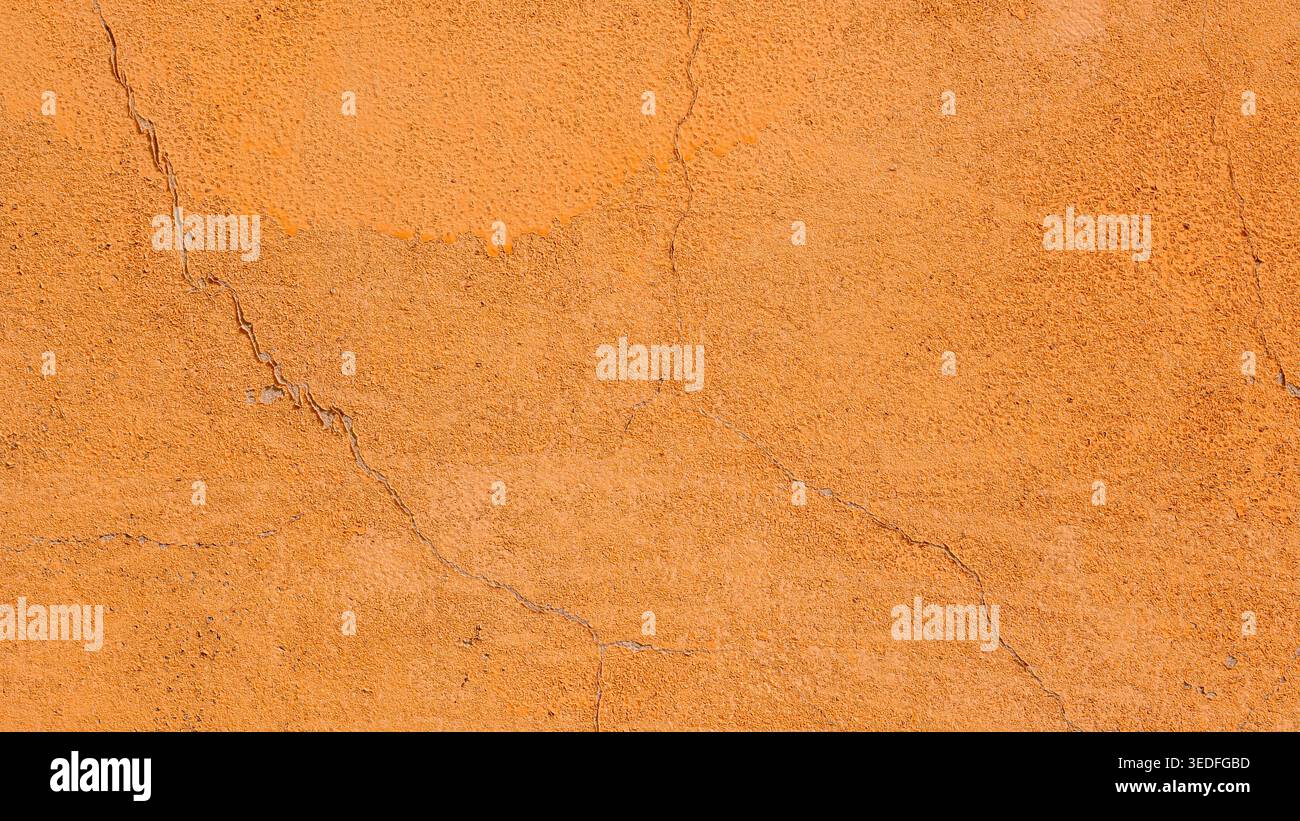 Orange plaster wall texture with cracks, rough stucco background Stock Photo