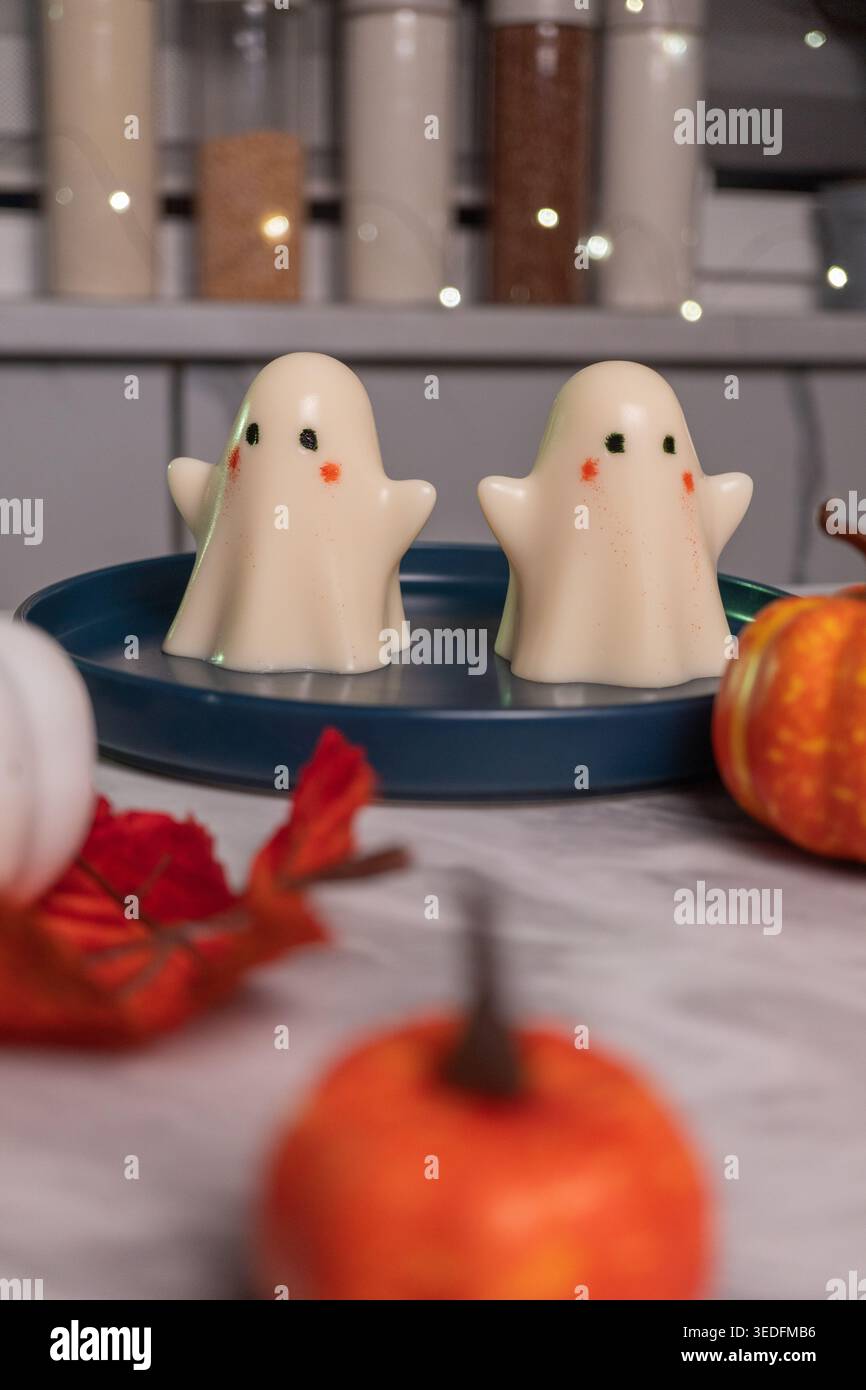 Cute ghost decorations on blue tray with mini pumpkins in festive autumn setting Stock Photo