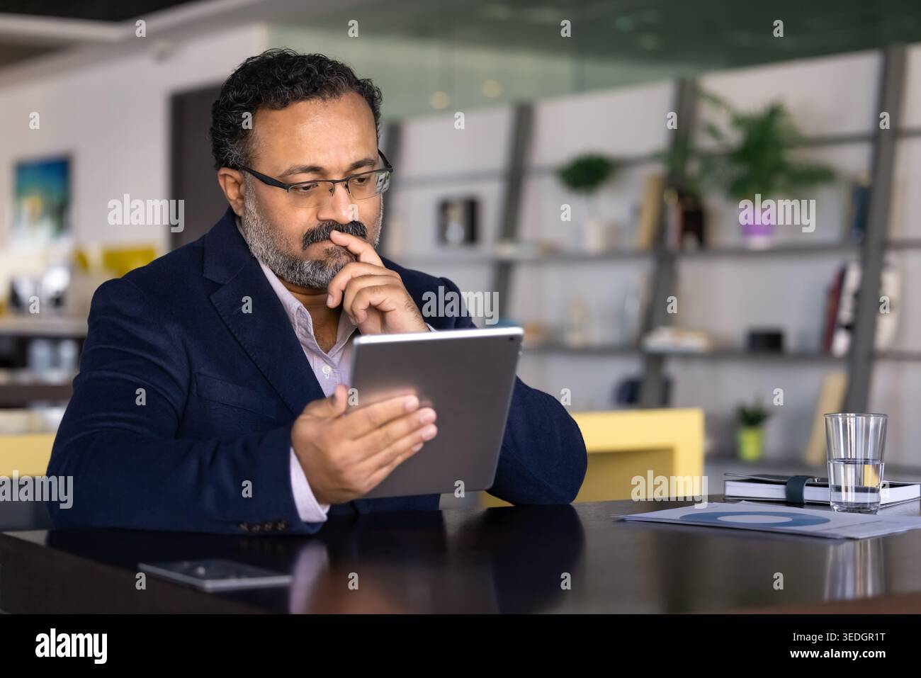 Professional man reviewing data on digital tablet Stock Photo