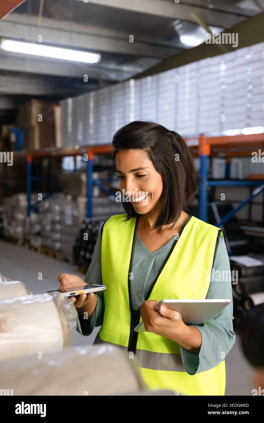 Female worker scanning barcode on package in warehouse Stock Photo
