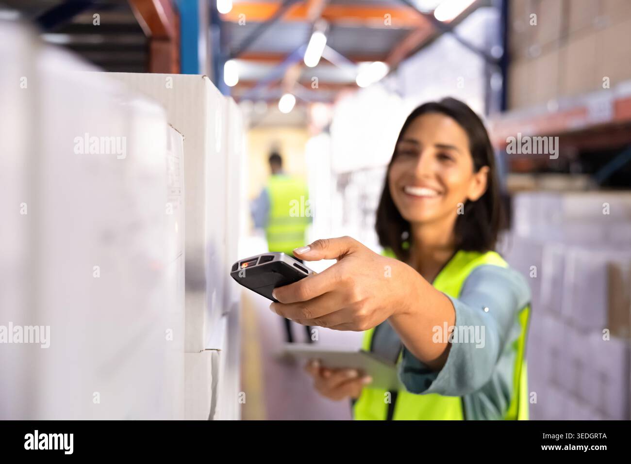 Closeup smiling female worker scanning barcode on box Stock Photo