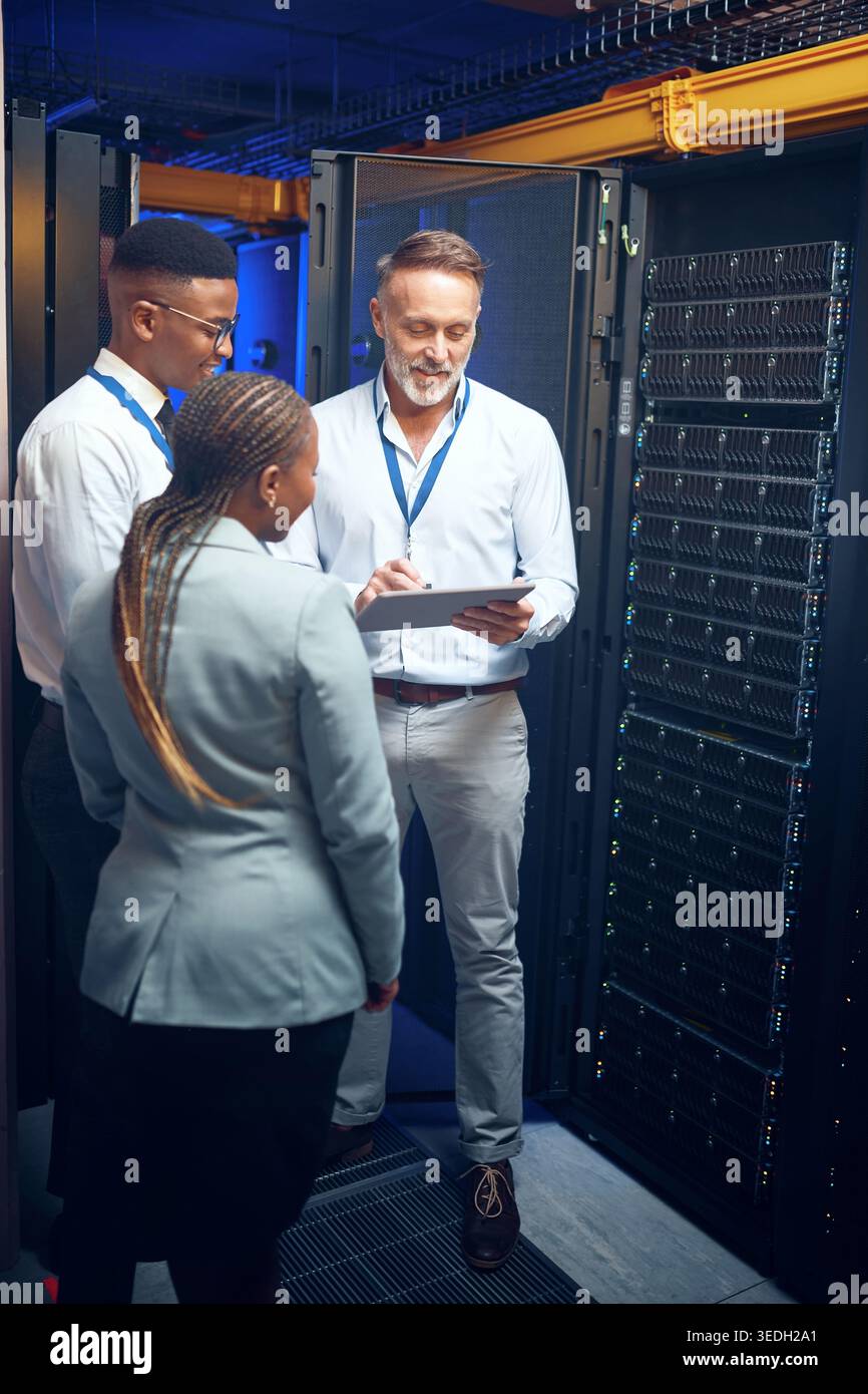 Cybersecurity, storage and tablet with people in server room together for problem solving or solution. App, collaboration and conversation with team Stock Photo