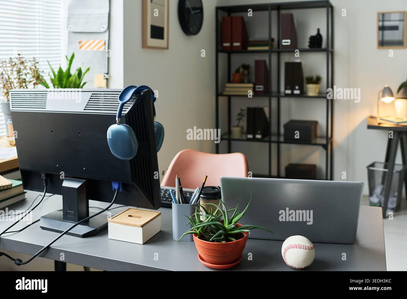 Home office workspace featuring desktop monitor, laptop, headphones, organizing tools for remote work and digital productivity. Ideal for hybrid work, freelance, startup marketing Stock Photo