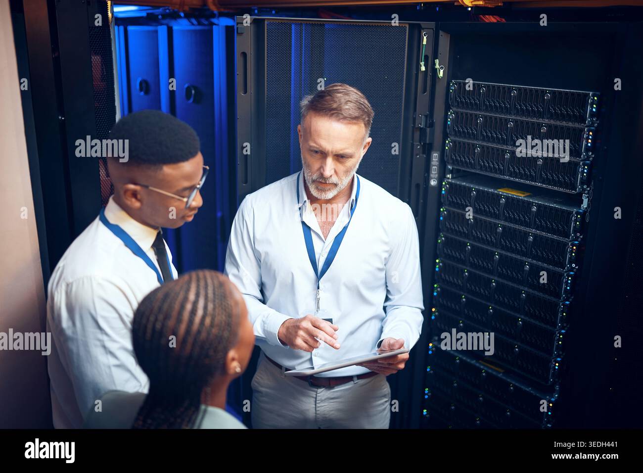 Cybersecurity, storage and tablet with team in data center together for problem solving or solution. App, collaboration and conversation with people Stock Photo