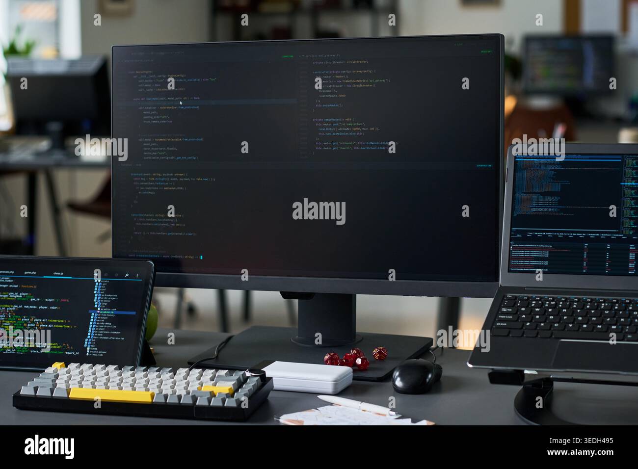 Close up of coding workstation displaying software development on multiple screens, supporting programming, cybersecurity, data engineering, or IT service marketing Stock Photo