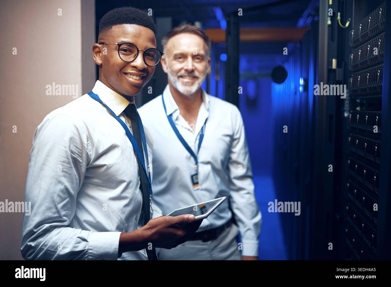 Portrait, storage and tablet with men in server room together for problem solving or solution. App, collaboration and cybersecurity with happy people Stock Photo