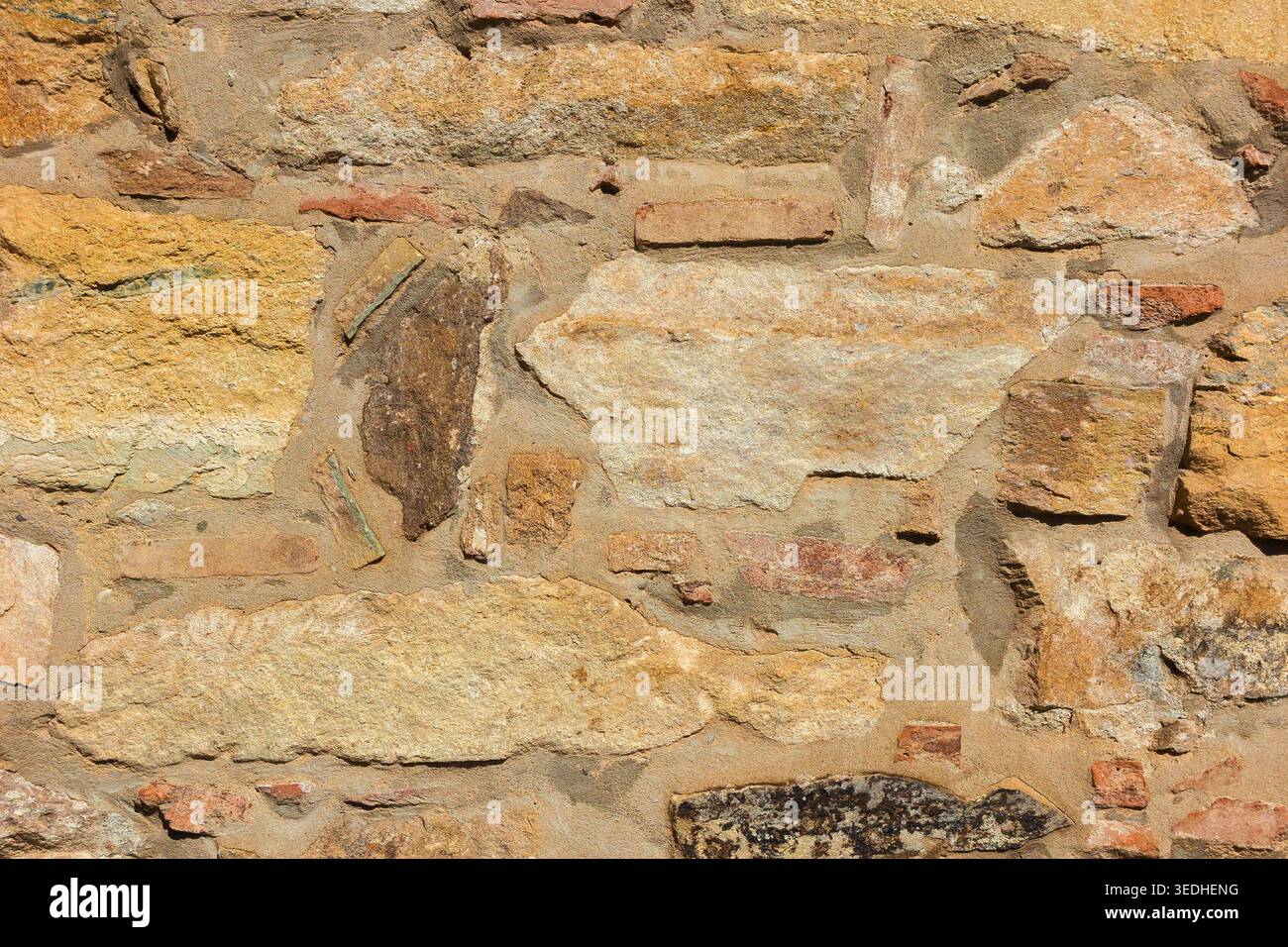 Ancient composite stone wall with bricks as background Stock Photo
