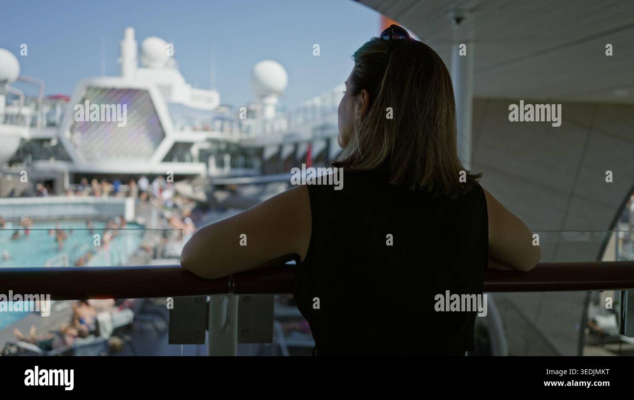 Resting On Railing Woman leans on ship rail with arms resting on railing and looks over ...