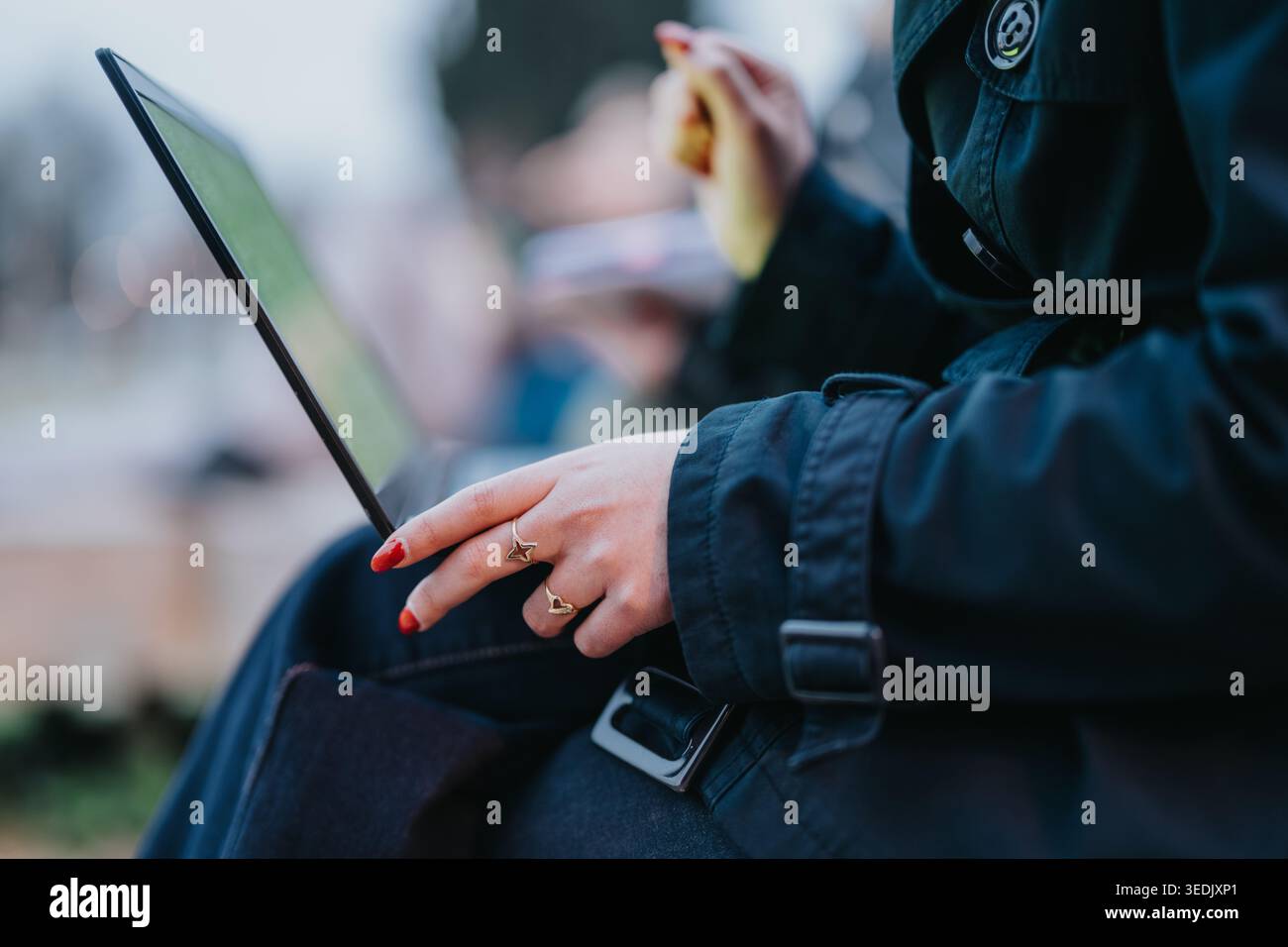 High school student using a laptop tablet outdoors while studying on a park bench Stock Photo