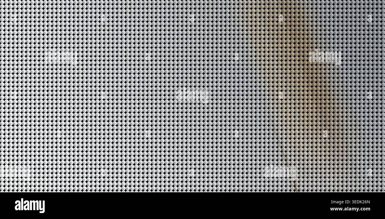 A high-resolution image of a metallic grid surface composed of small circular elements, featuring a soft diagonal light gradient across the pattern. Stock Photo