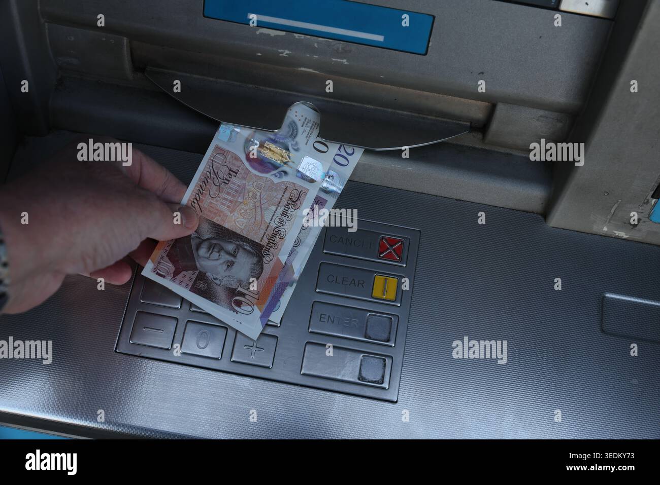 King Charles III Bank of England notes being dispensed from a UK ATM cash machine, showing the new monarch on British currency. Stock Photo