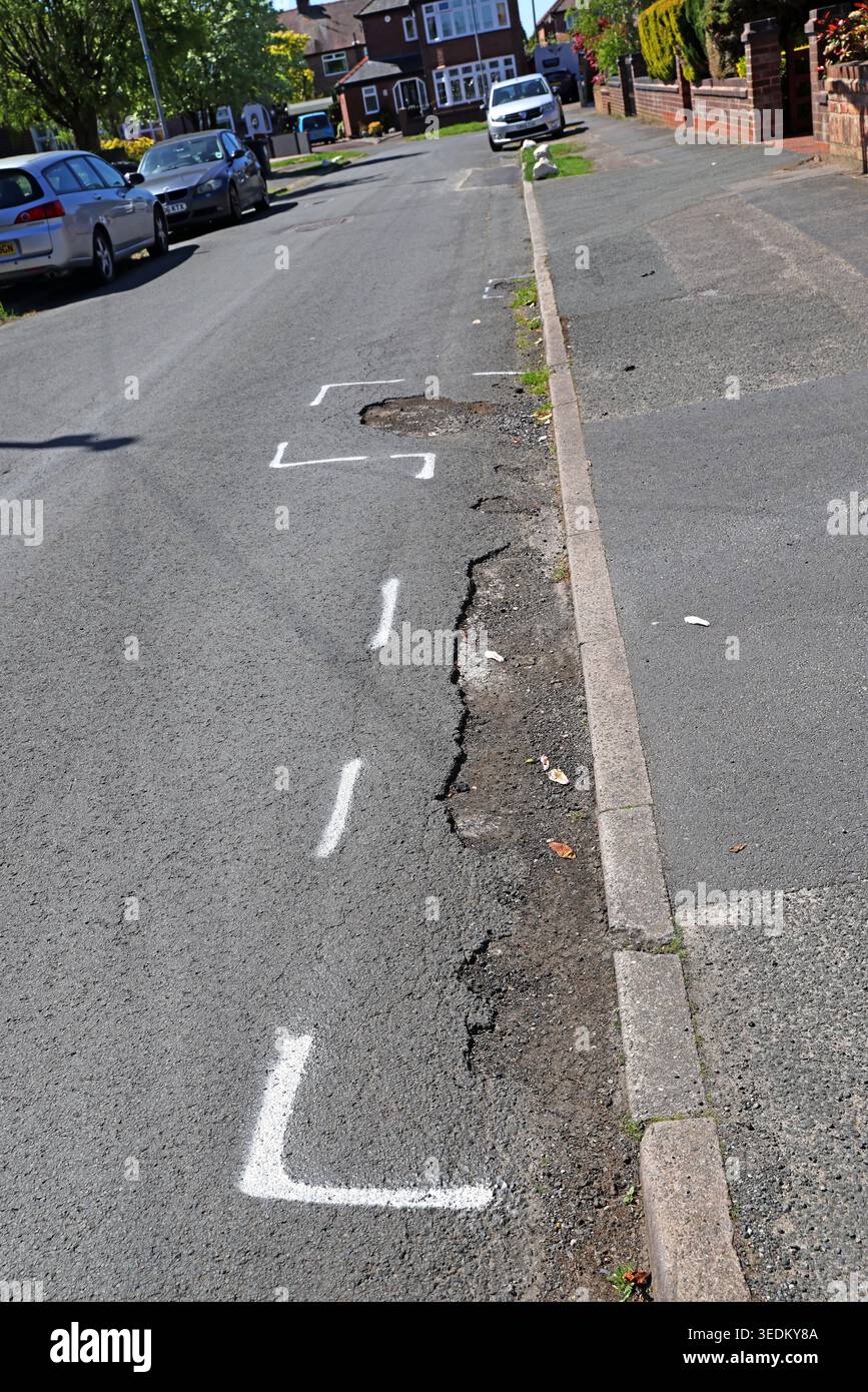 Residential street potholes marked for repair - Warrington, Warrington, Cheshire, England, UK. Stock Photo