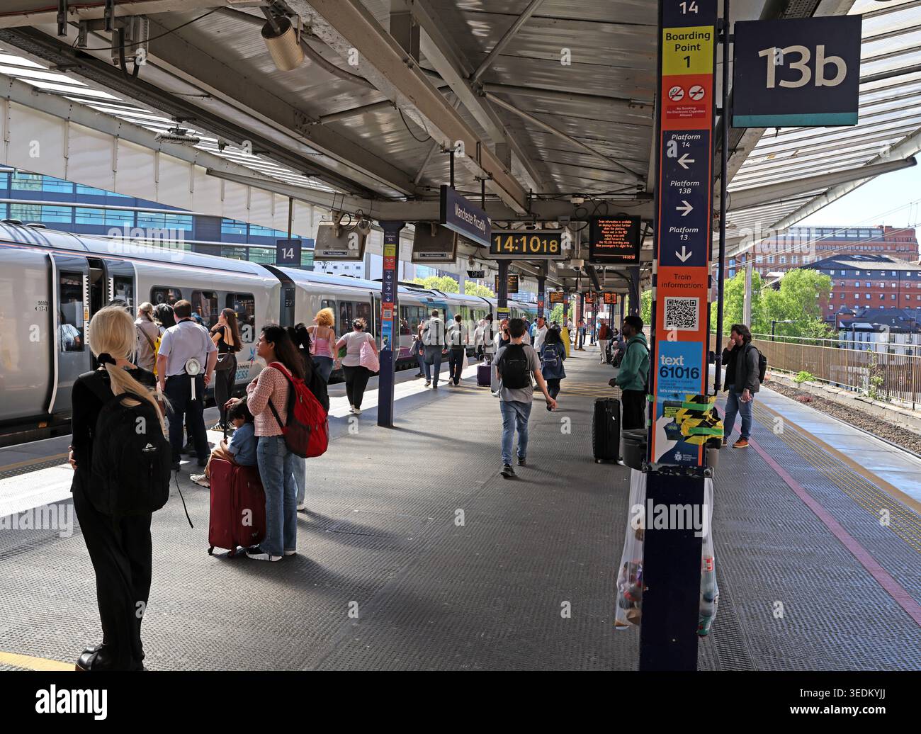 Crowded Platforms 13 and 14 at Manchester Piccadilly, the constrained through route towards Oxford Road and Deansgate stations Stock Photo