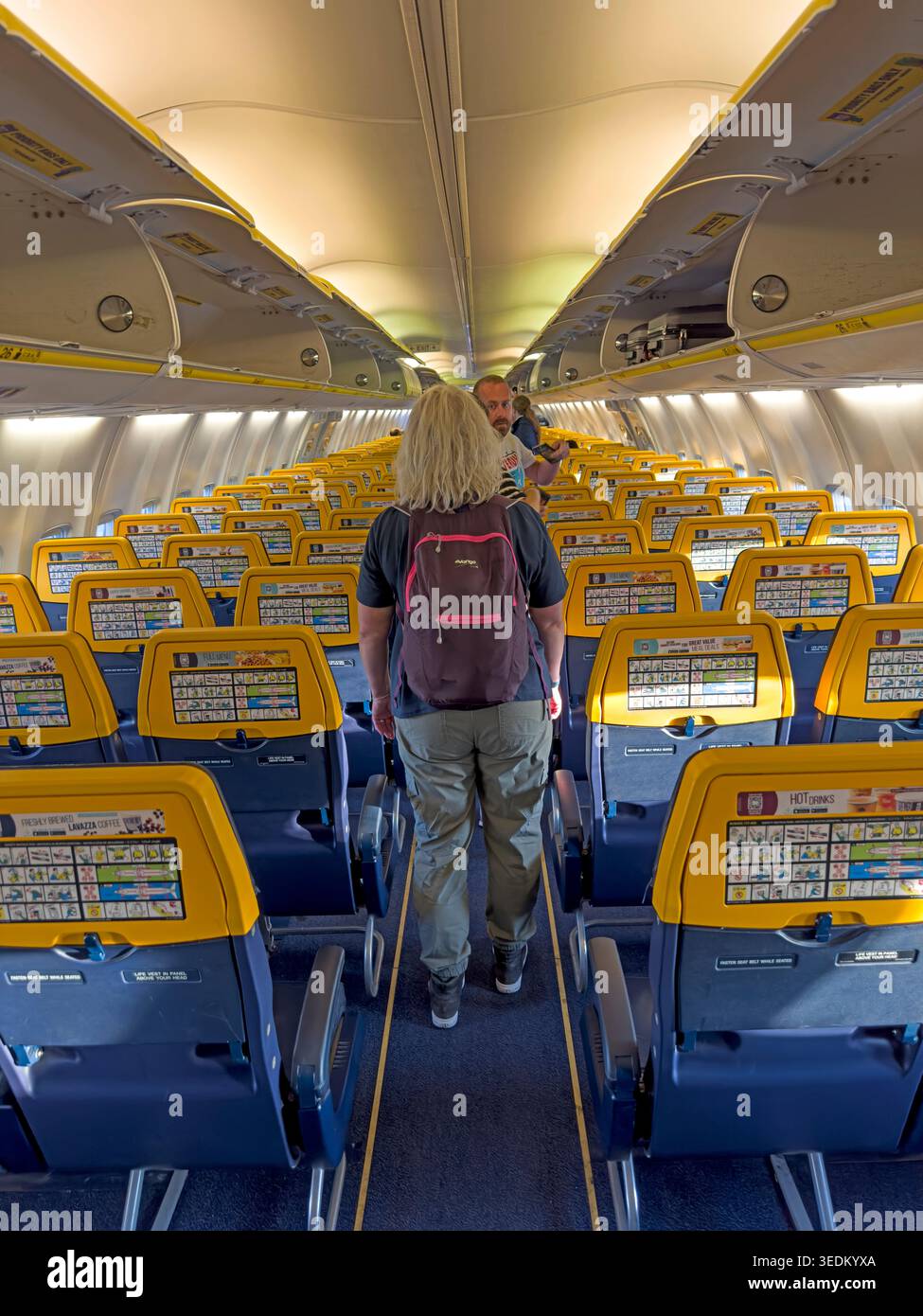Inside a Ryanair aircraft as passengers board an economy cabin prepared for a low-cost short-haul flight within Europe. Stock Photo