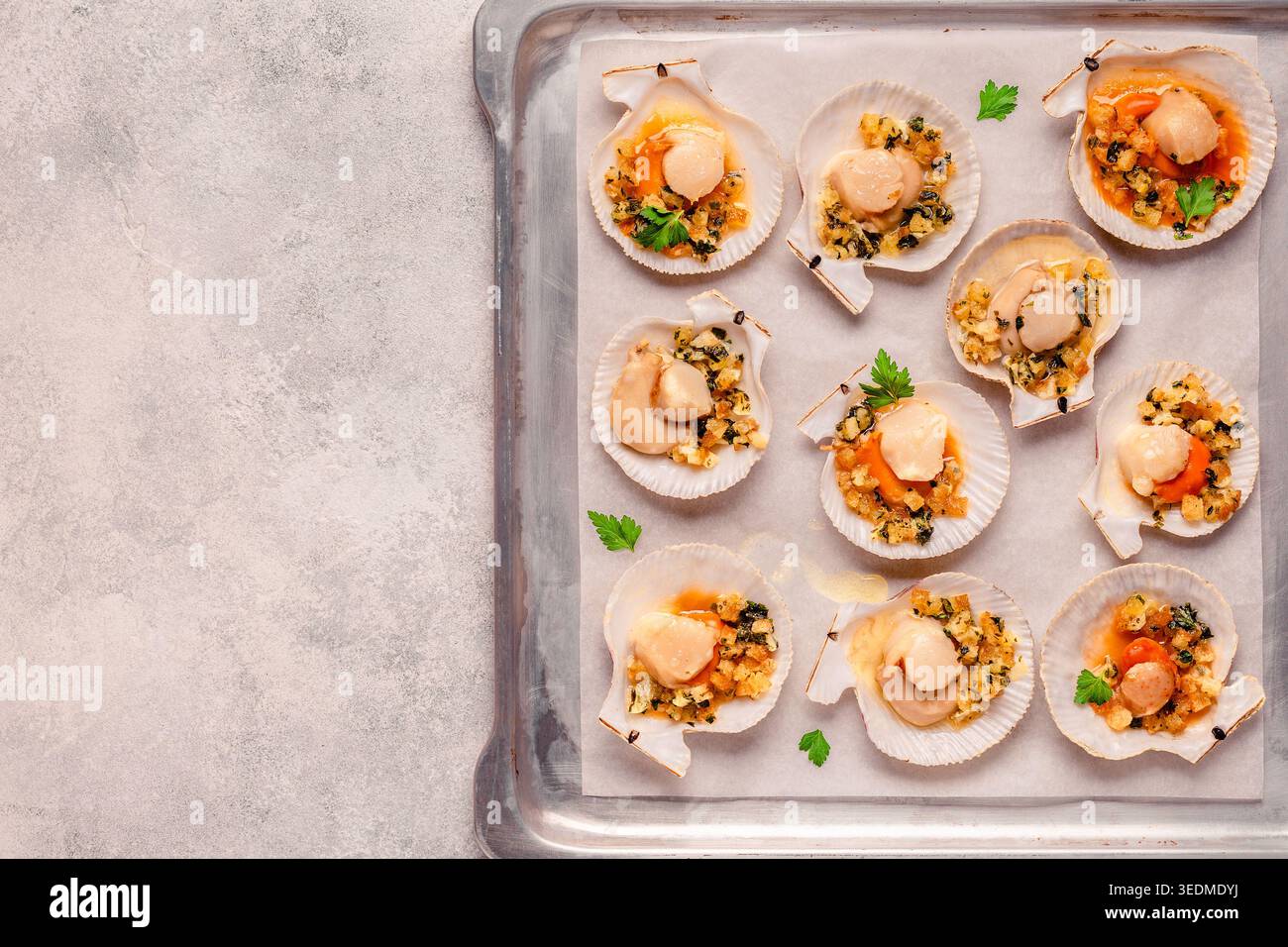 Cooked scallops with sauce on a baking sheet Stock Photo