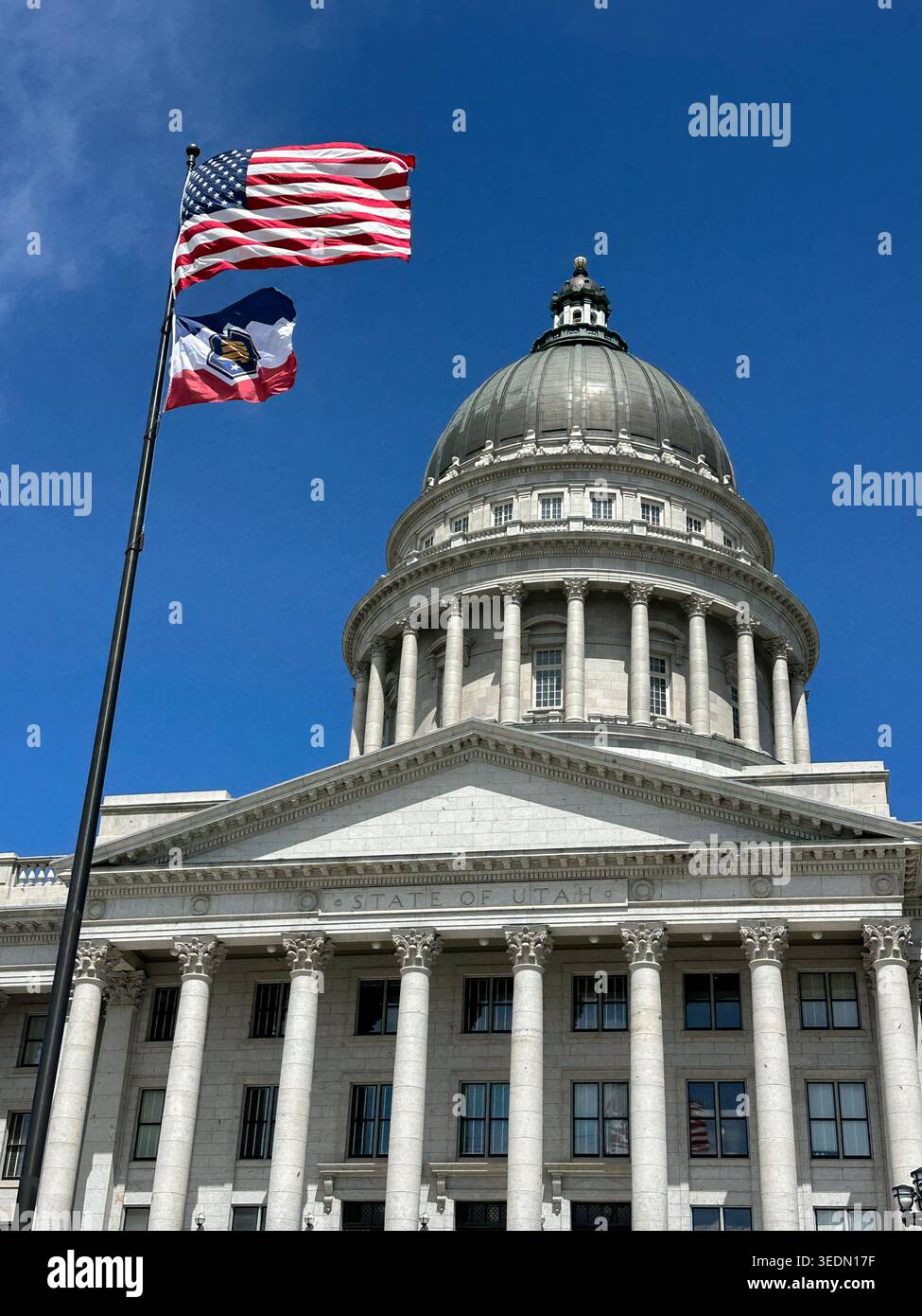 Utah State Capitol Building with American flag and Utah State flag against blue sky - Smartphone Captured Stock Image