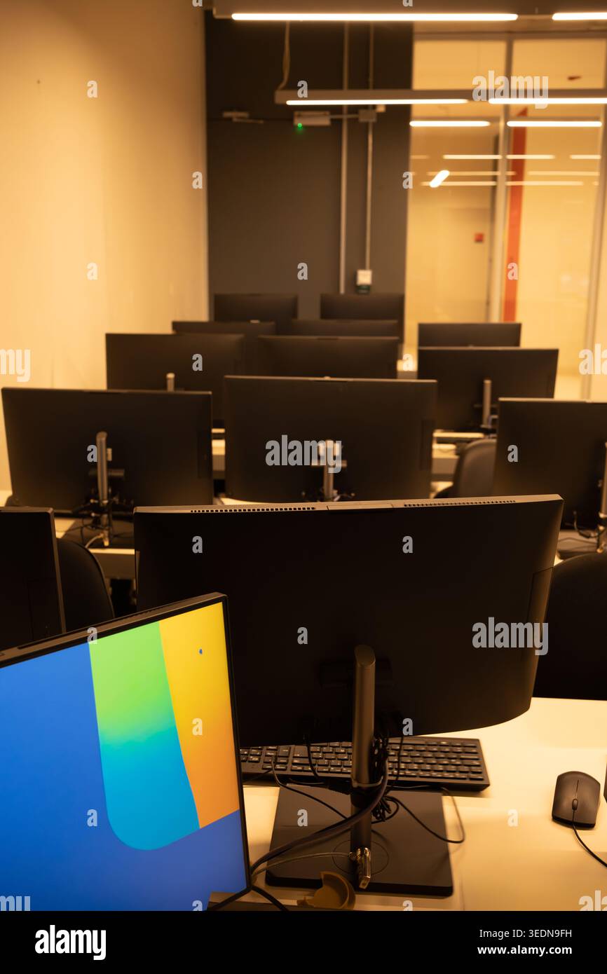 IT Training Center Interior with Desktop Computers in Warm Light, vertical image Stock Photo