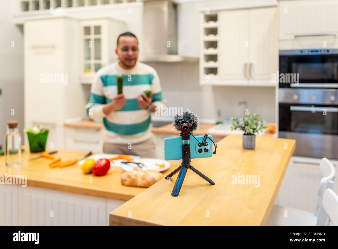 Male vlogger recording cooking tutorial in kitchen Stock Photo