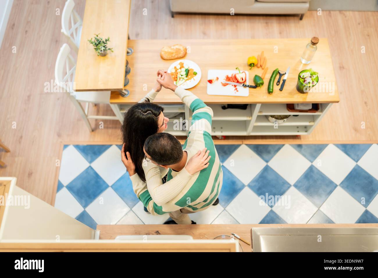 Loving couple dancing in kitchen preparing healthy meal Stock Photo