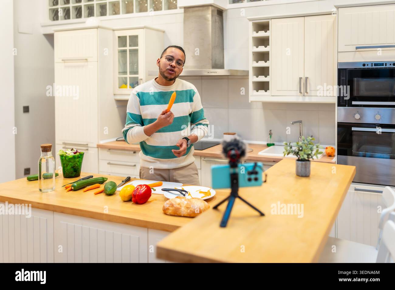 Man vlogger recording cooking video in kitchen Stock Photo