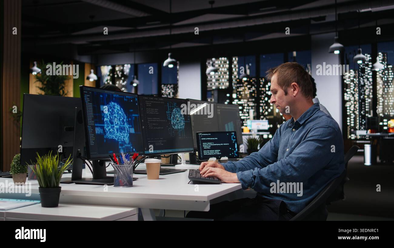 Tech startup IT expert developing artificial intelligence algorithms in high rise office late at night. System administrator debugging neural network brain models on screens Stock Photo