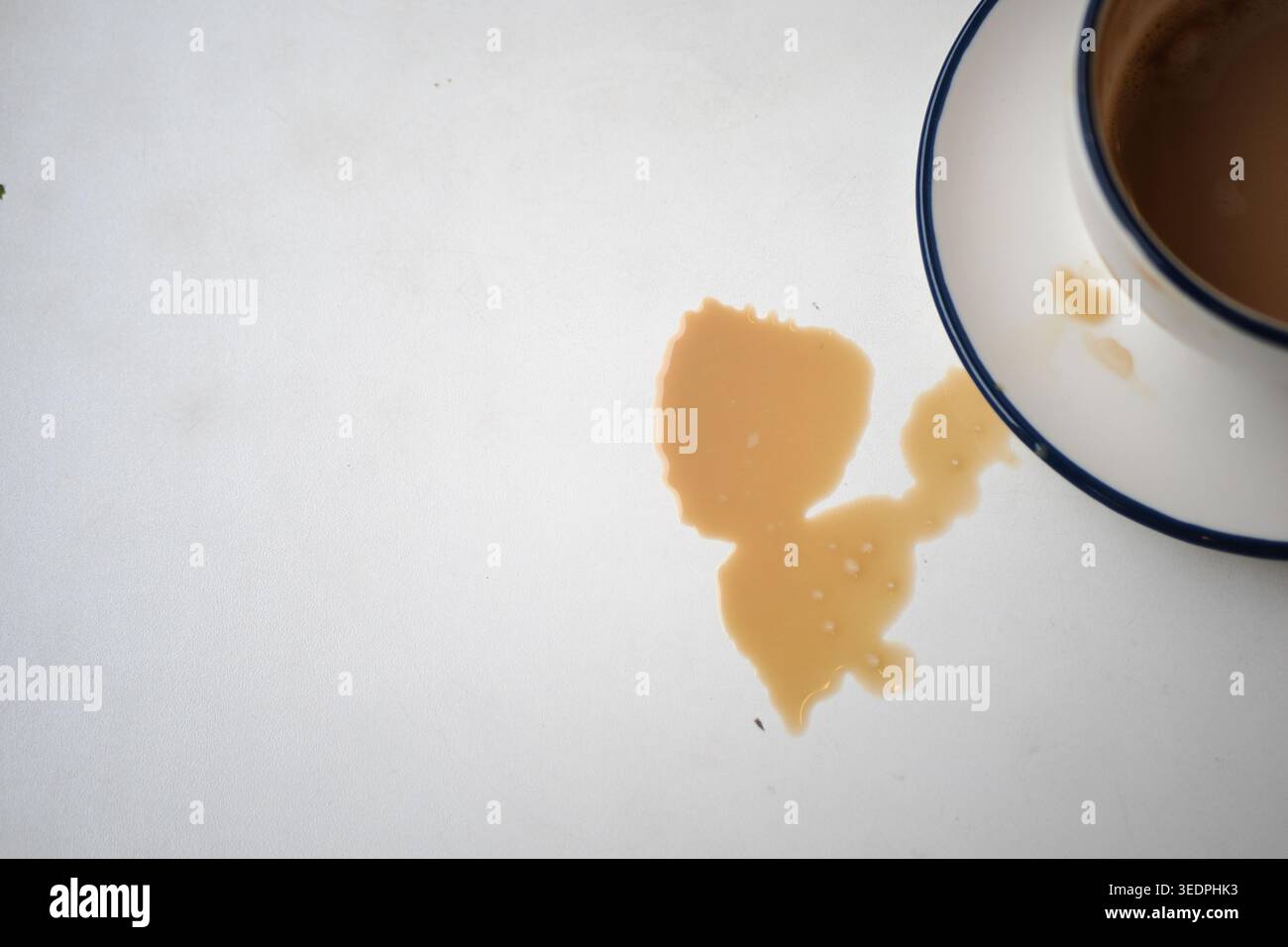 Coffee spills on a table near an empty cup Stock Photo