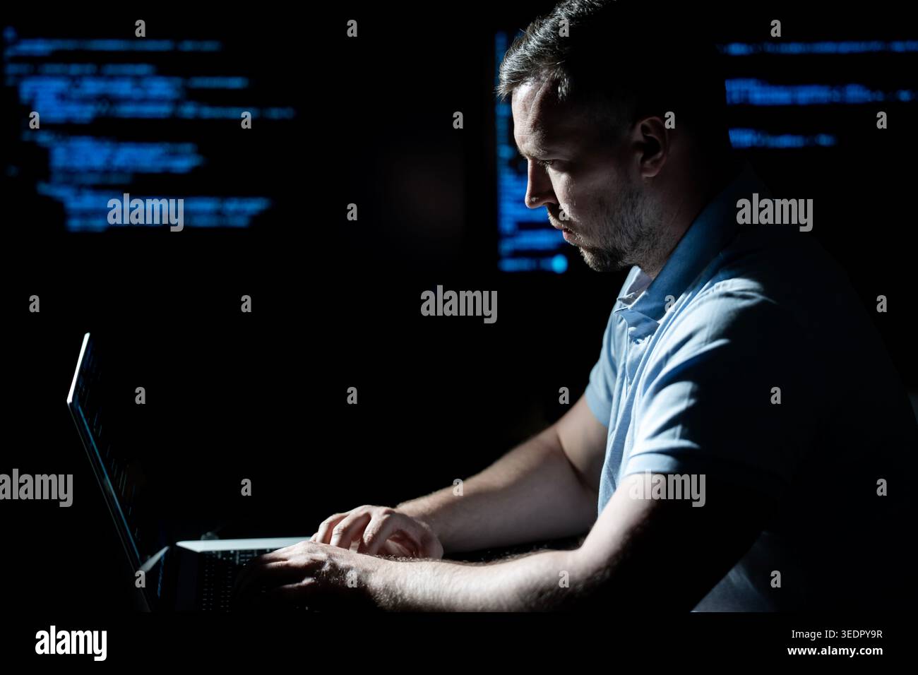 Hacker types code on laptop keyboard. Hacker analyzes system vulnerability at night. Hacker monitors server and database access. Hacker launches cyber Stock Photo