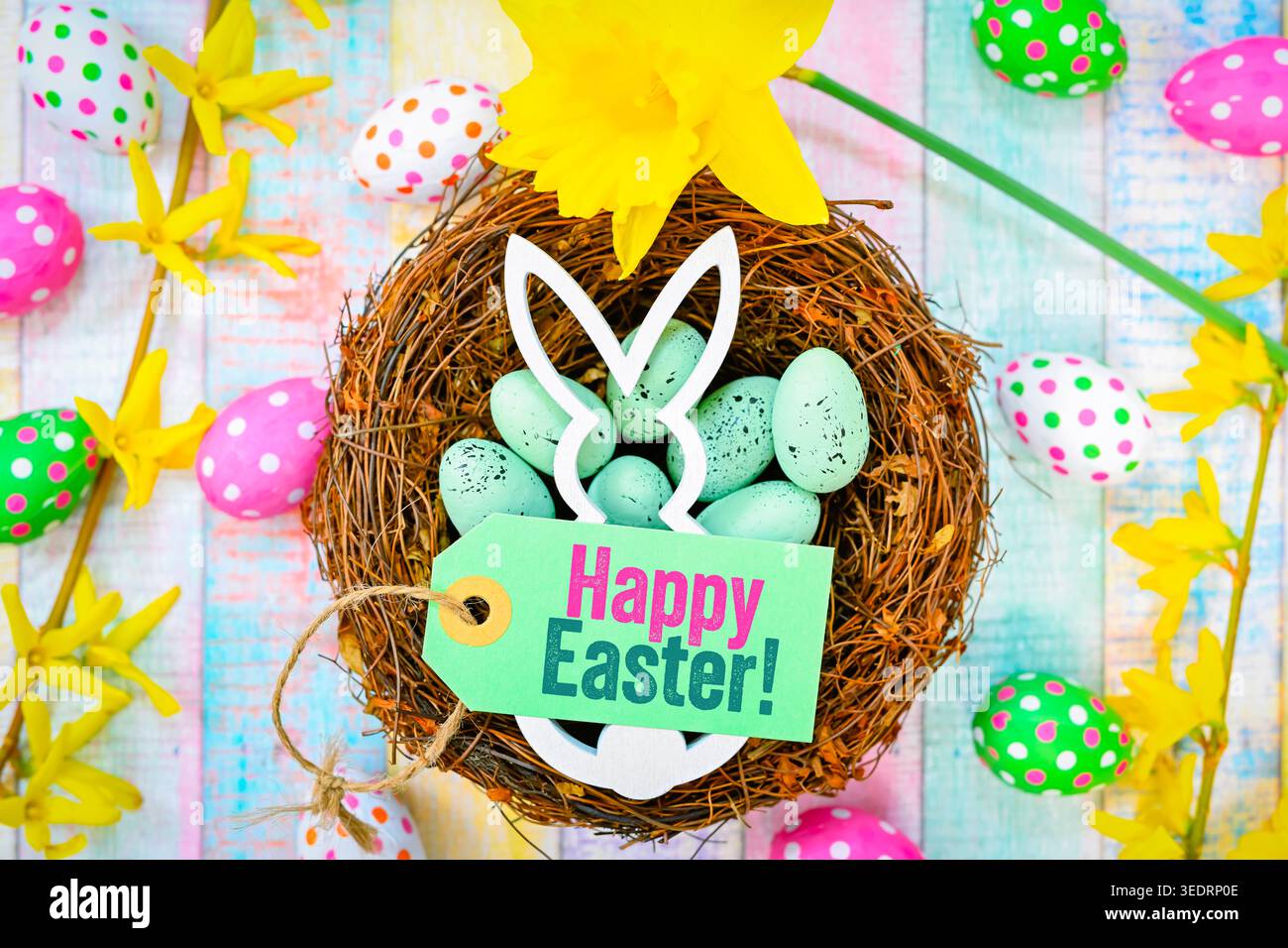 Easter bunny in Easter nest with Easter eggs and label with Easter greeting happy Easter, photomontage Stock Photo