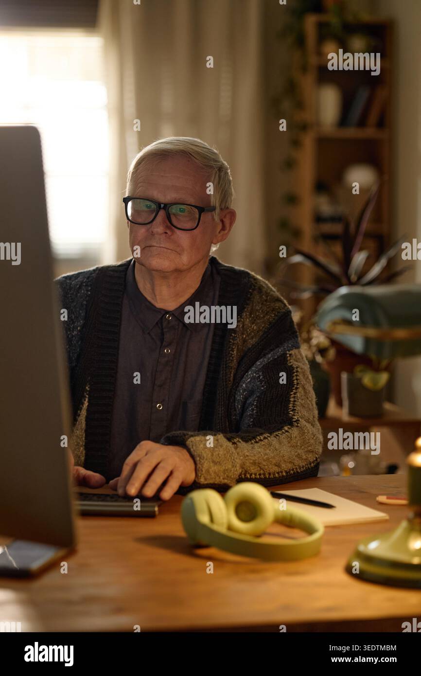 Senior Man Working on Desktop Computer in Home Office Stock Photo