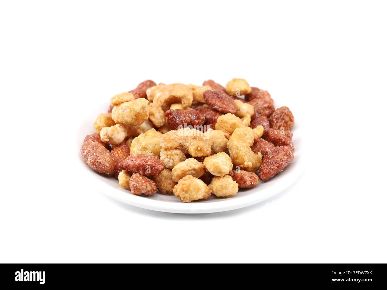 Mix of caramelized nuts: cashew,almonds and peanuts on a white plate. White background. Stock Photo