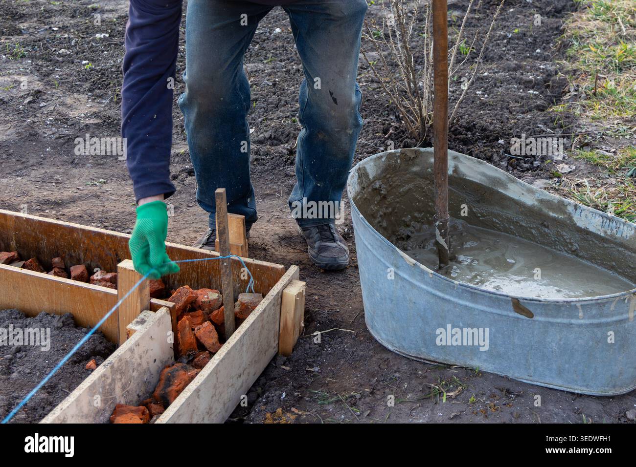 Foundation String Line Worker Aligning Formwork For Concrete Foundation. Worker adjusts string ...